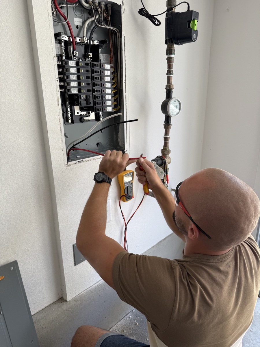 Alex testing wiring at an electrical panel