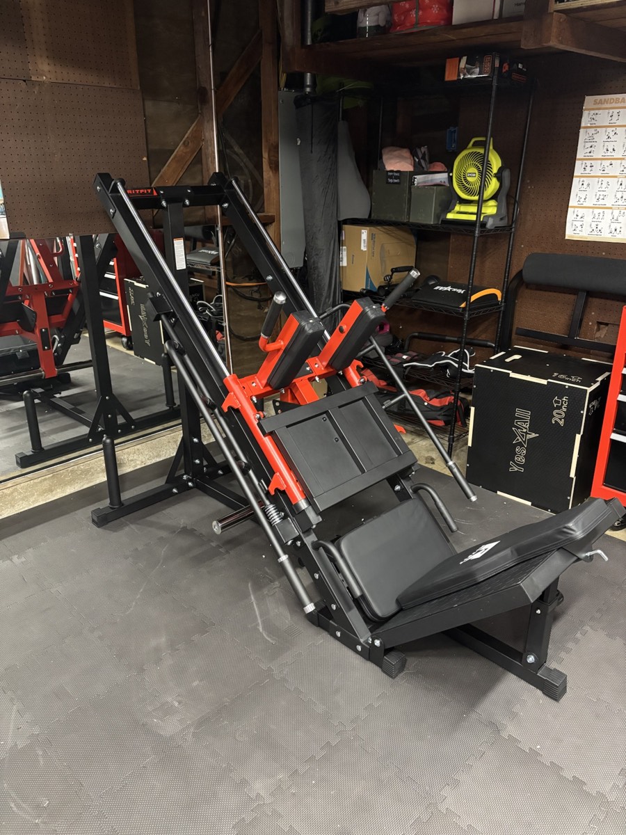 Red and black strength-training machine assembled in a home gym
