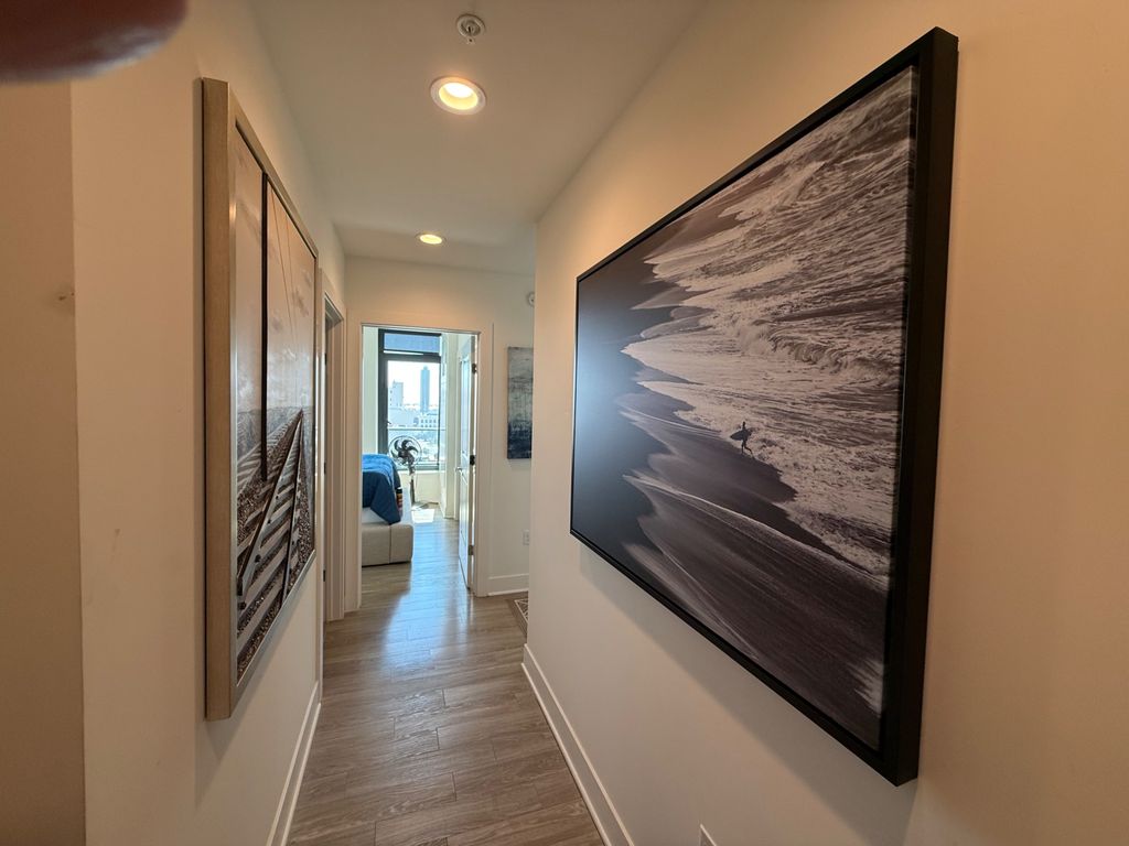 Large framed ocean photographs mounted along a finished hallway