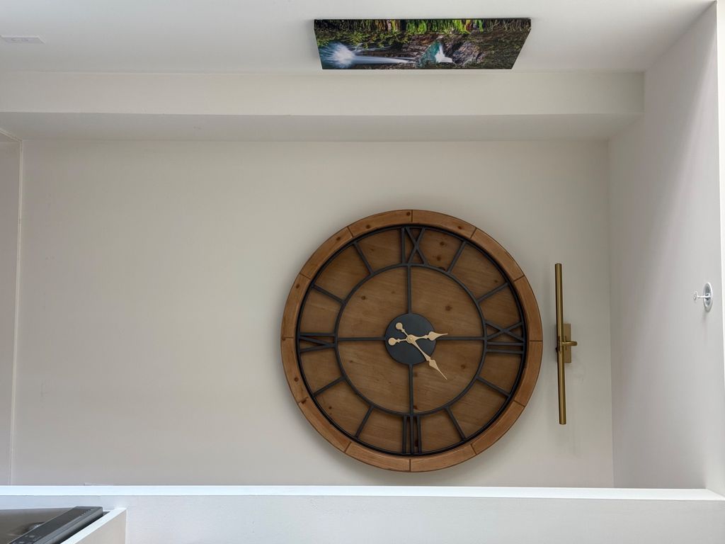 Oversized round wall clock mounted in a recessed alcove
