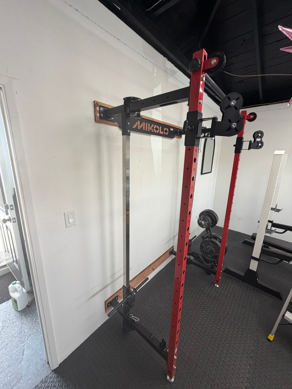 Second view of the assembled wall-mounted gym rack and cable system